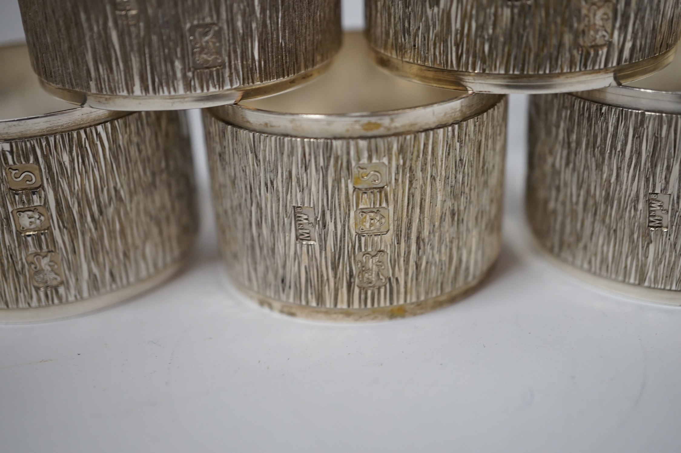A set of six Elizabeth II textured silver napkin rings, Mappin & Webb, London, 1973, 46mm, 10.9oz, with Mappin & Webb box.